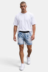Model wearing KIOKO blue and white tie-dye cotton jogger shorts with a drawstring waist and a plain white t-shirt.