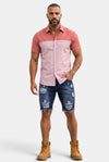 KIOKO Cityboy colorblock short-sleeve button-down shirt in pink and coral worn by a man with distressed denim shorts.