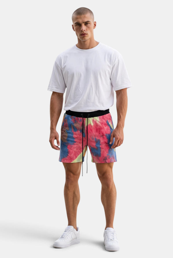 KIOKO Cypher tie-dye jogger shorts in blue and pink with an elastic drawstring waistband worn by a male model.