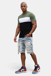 KIOKO Eastside colorblock t-shirt in olive, white, and black worn by a man with distressed denim cargo shorts