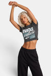 KIOKO Hustle Culture crop top in washed charcoal grey cotton, back view on a blonde model with black sweatpants.