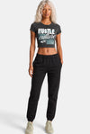 KIOKO Hustle Culture crop top in washed charcoal grey cotton, back view on a blonde model with black sweatpants.