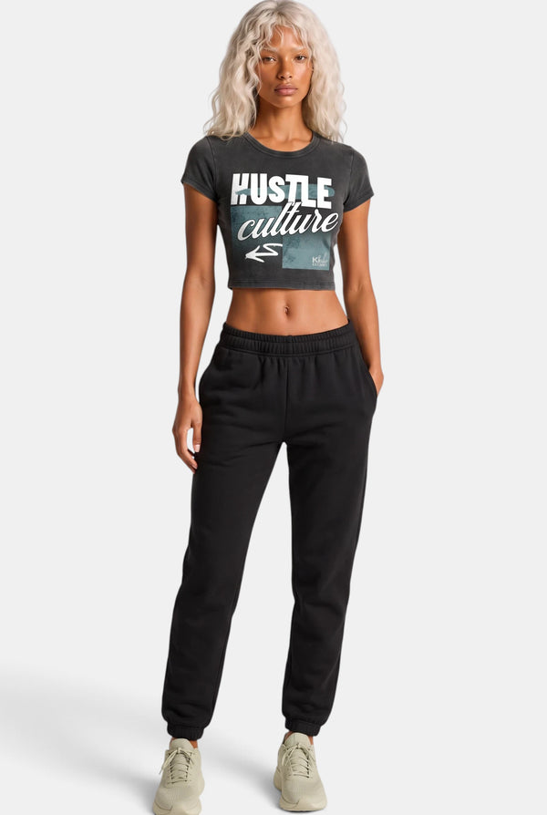 KIOKO Hustle Culture crop top in washed charcoal grey cotton, back view on a blonde model with black sweatpants.