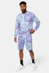 Model wearing KIOKO lavender paisley bandana print crewneck sweatshirt and matching shorts with ribbed cuffs