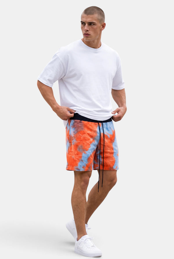 KIOKO model wearing red and blue tie-dye cotton jogger shorts with an elastic drawstring waist and relaxed fit