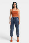 KIOKO Sculpt & Slay halter sports bra in rust orange, worn by a model with dark hair against a neutral background.